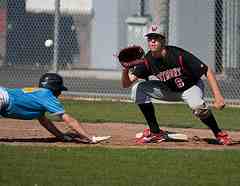 runner diving back to first base on pick off throw from pitcher
