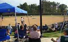 baseball parents bring their own chairs and gather round the backstop